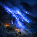 Blue fire phenomenon at Mount Ijen volcano during a midnight hike, East Java, Indonesia, with glowing blue flames and hikers watching before sunrise.